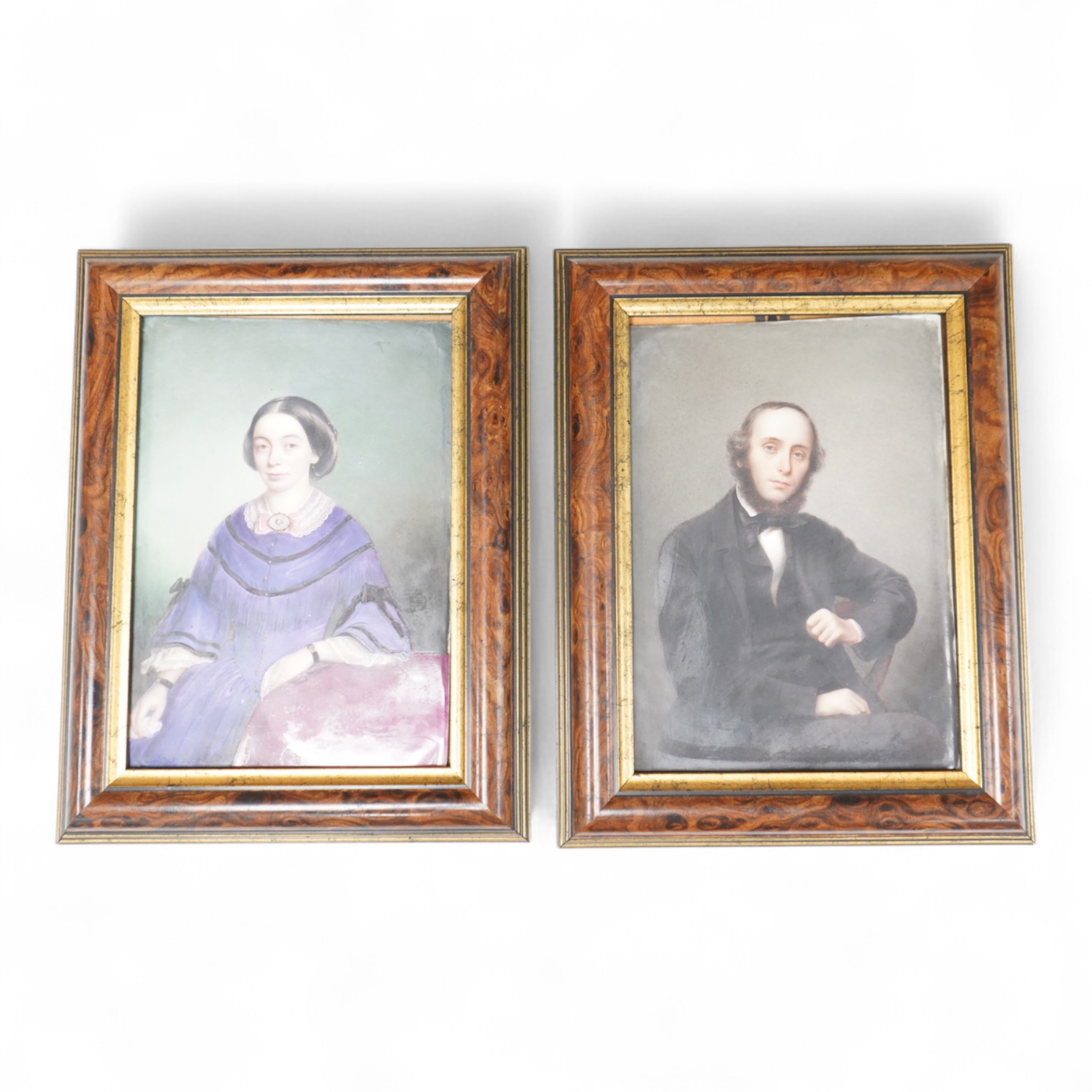 A pair of mid 19th century German portrait painted porcelain plaques of a husband and wife, housed in burr wood frames, overall 25cm high